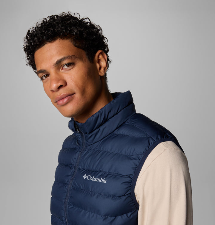 Men's navy quilted vest close-up with full-zip front and chest logo