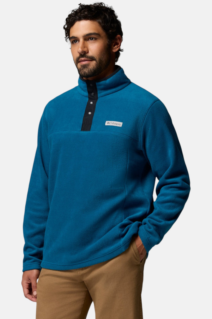 Blue fleece half-snap pullover in profile view with stand collar and chest logo patch