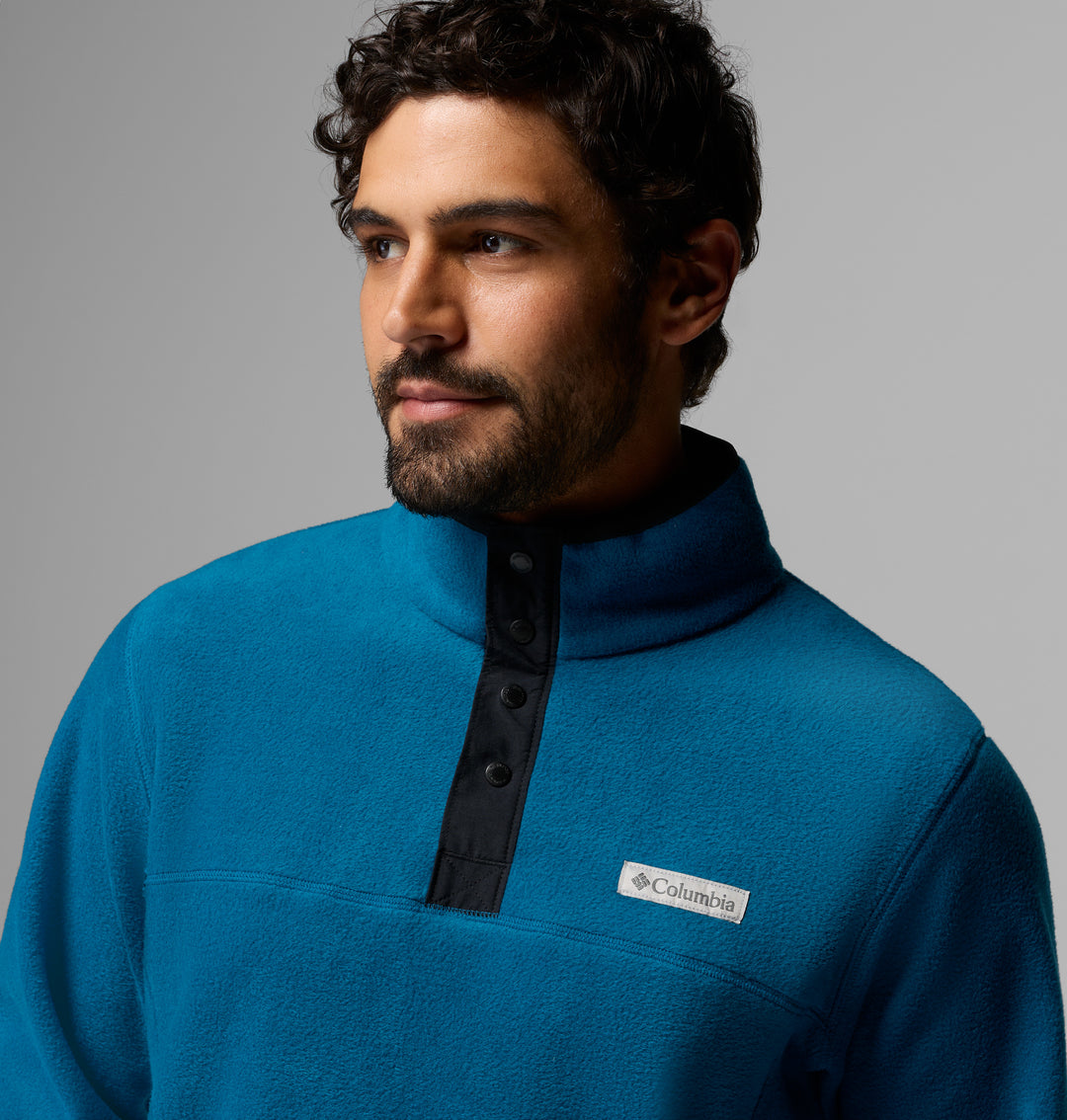 Blue fleece half-snap pullover close-up, stand collar with dark button placket and logo