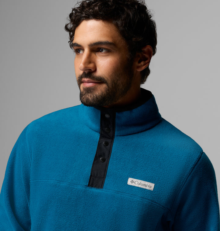 Blue fleece half-snap pullover close-up, stand collar with dark button placket and logo