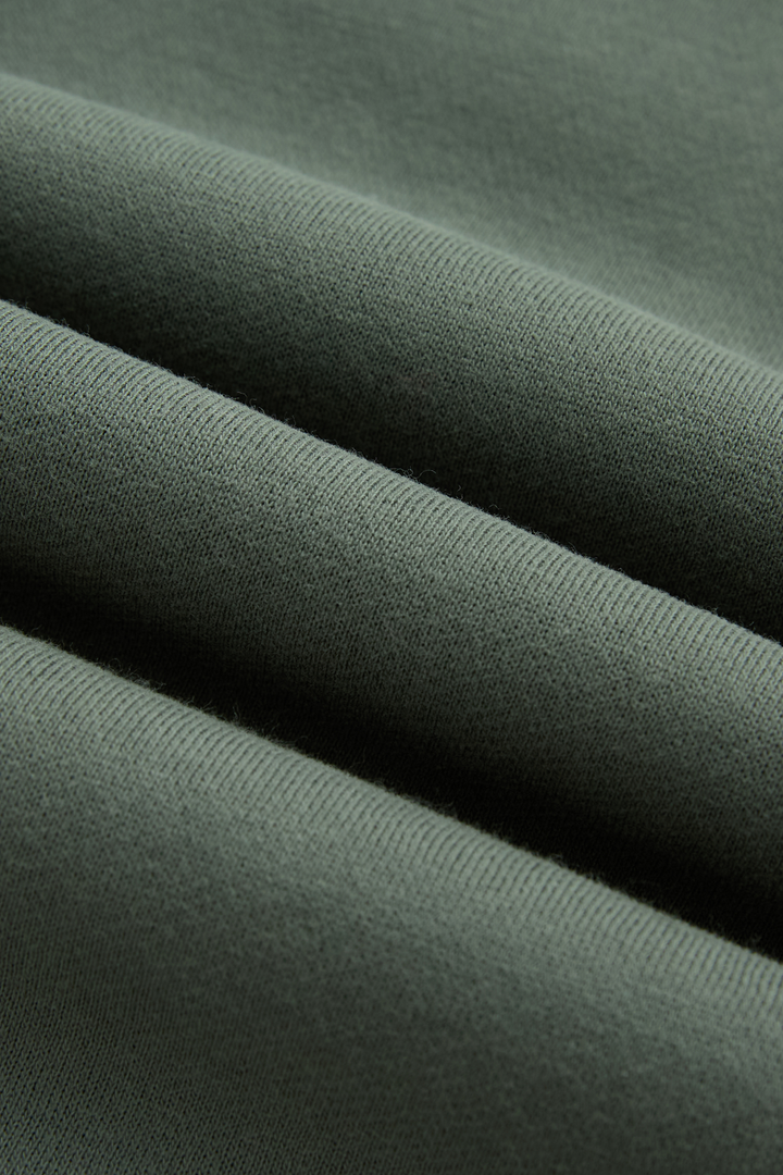 Green hoodie fabric close-up showing its soft knit texture