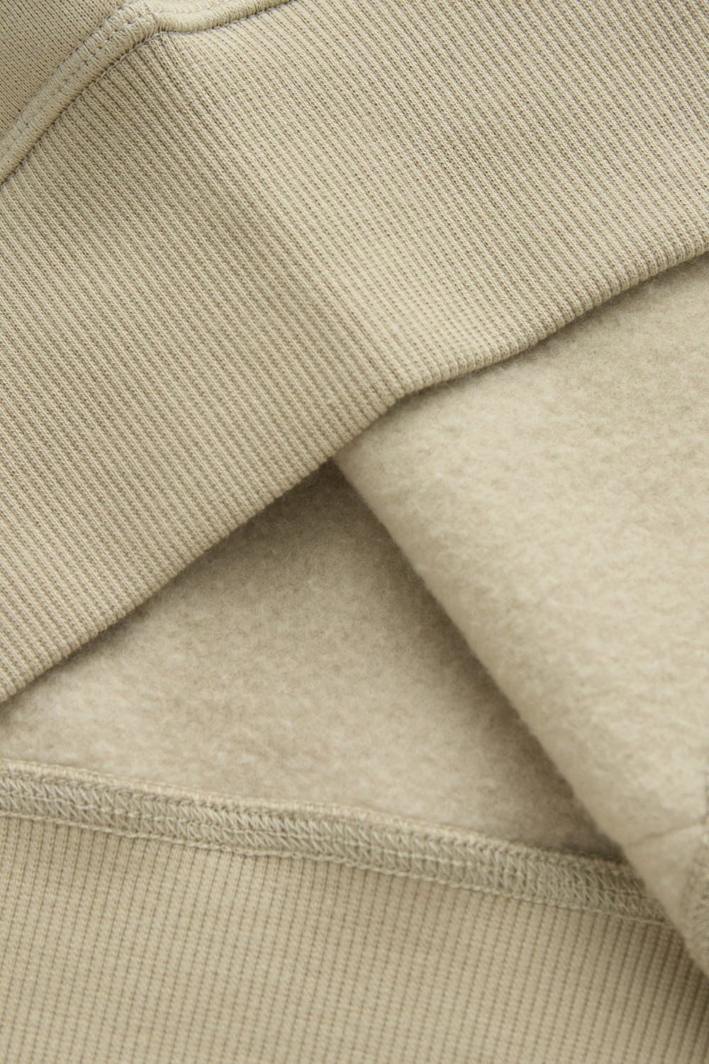 Hoodie fabric close-up showing ribbed knit exterior and soft brushed interior