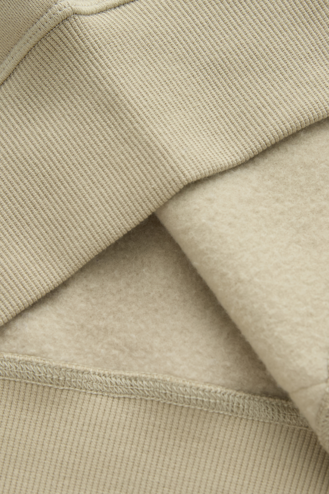 Hoodie fabric close-up showing ribbed knit exterior and soft brushed interior