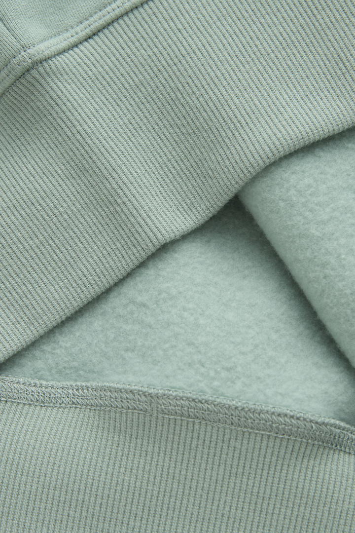 Jade hoodie fabric close-up showing soft fleece lining and ribbed seam