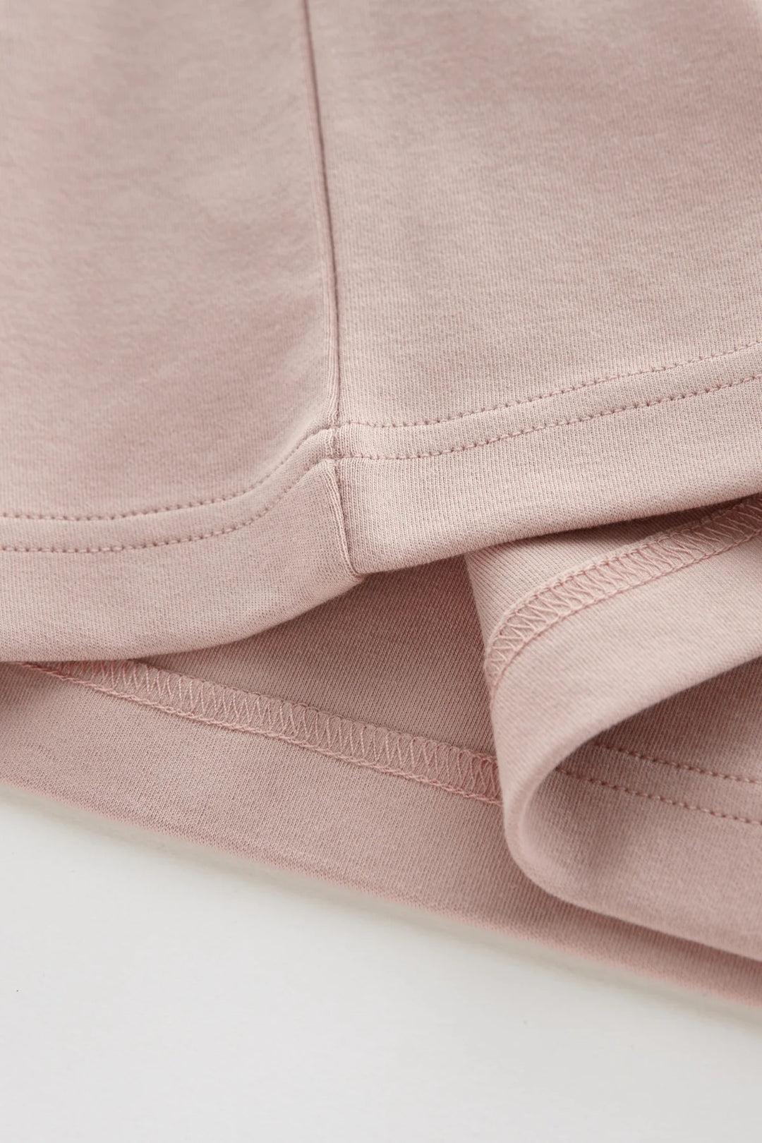 Rose Liquid T-shirt hem and side seam close-up