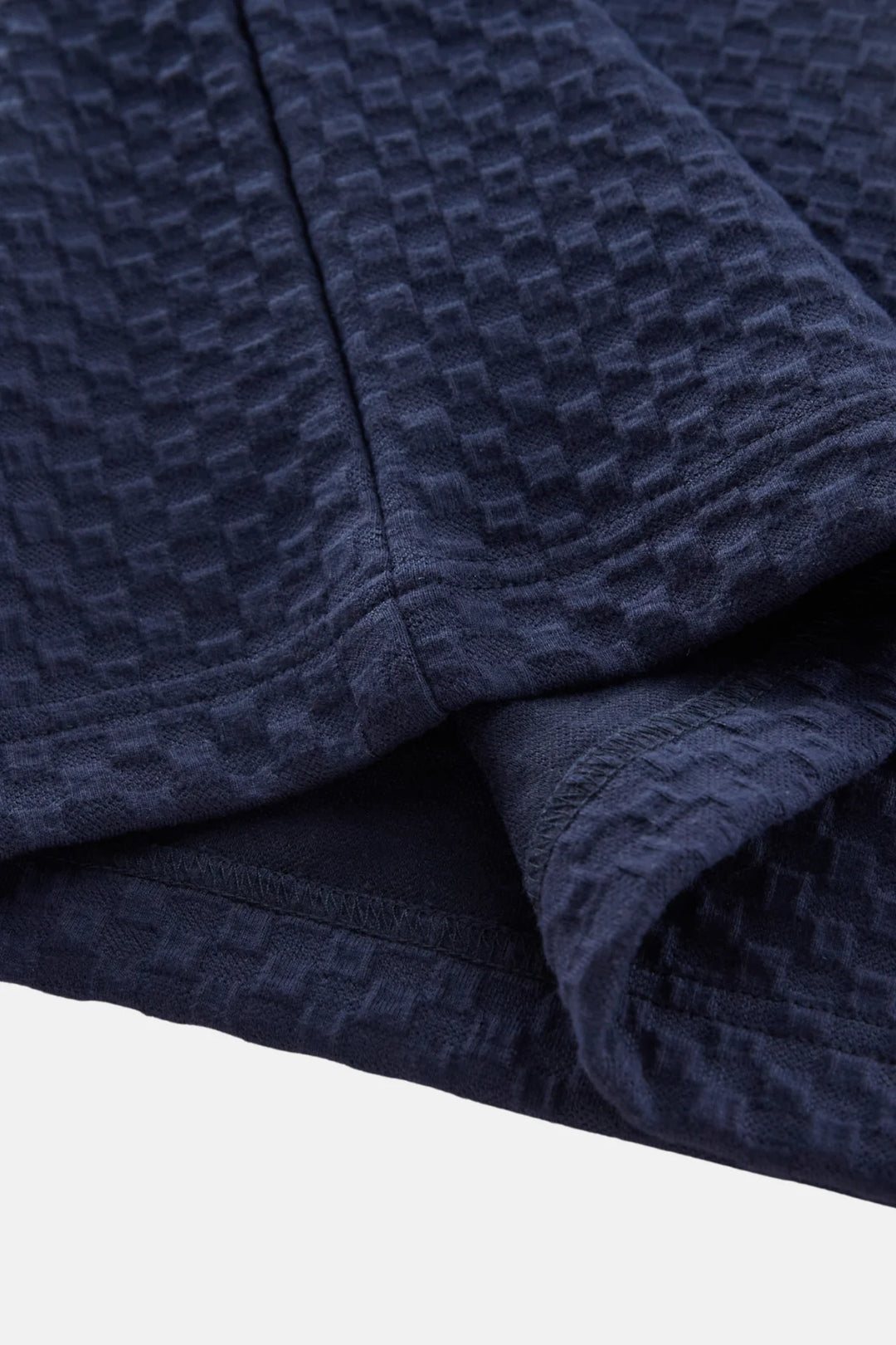 Navy jacquard polo shirt sleeve seam and folded collar edge