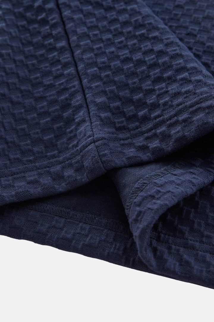 Navy jacquard polo shirt sleeve seam and folded collar edge