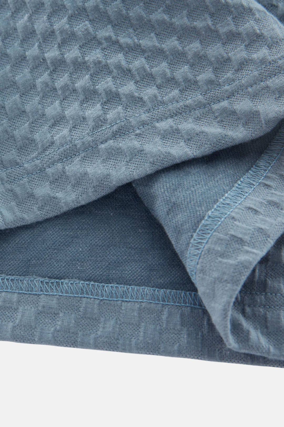 Polo shirt sleeve and hem detail in light blue jacquard fabric