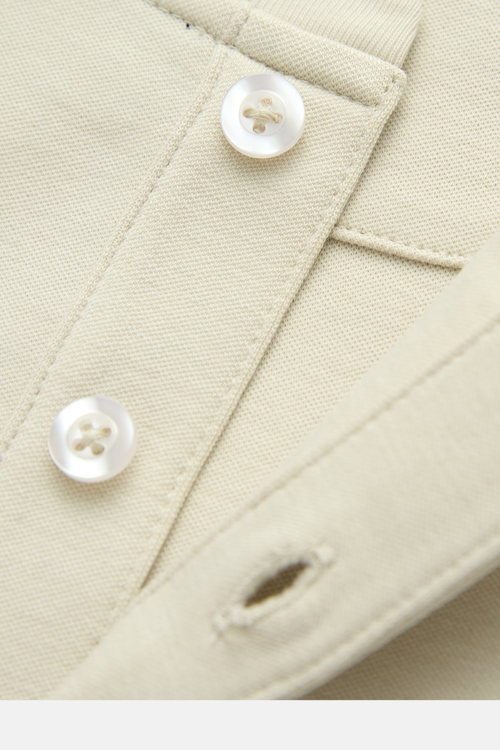 Close-up of the bone top's textured fabric, buttons, and buttonhole