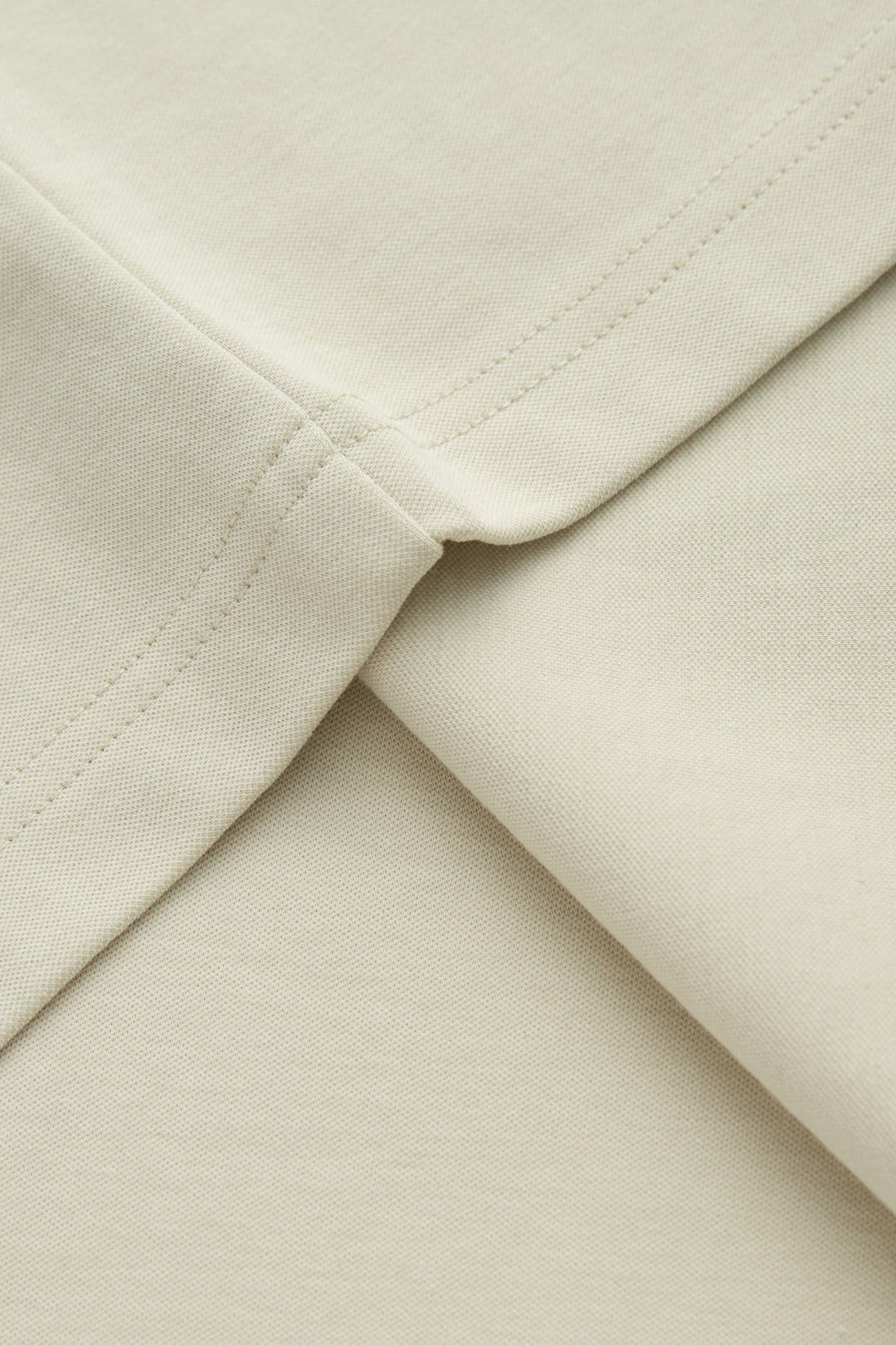 Close-up of the top's bone fabric and stitched seam