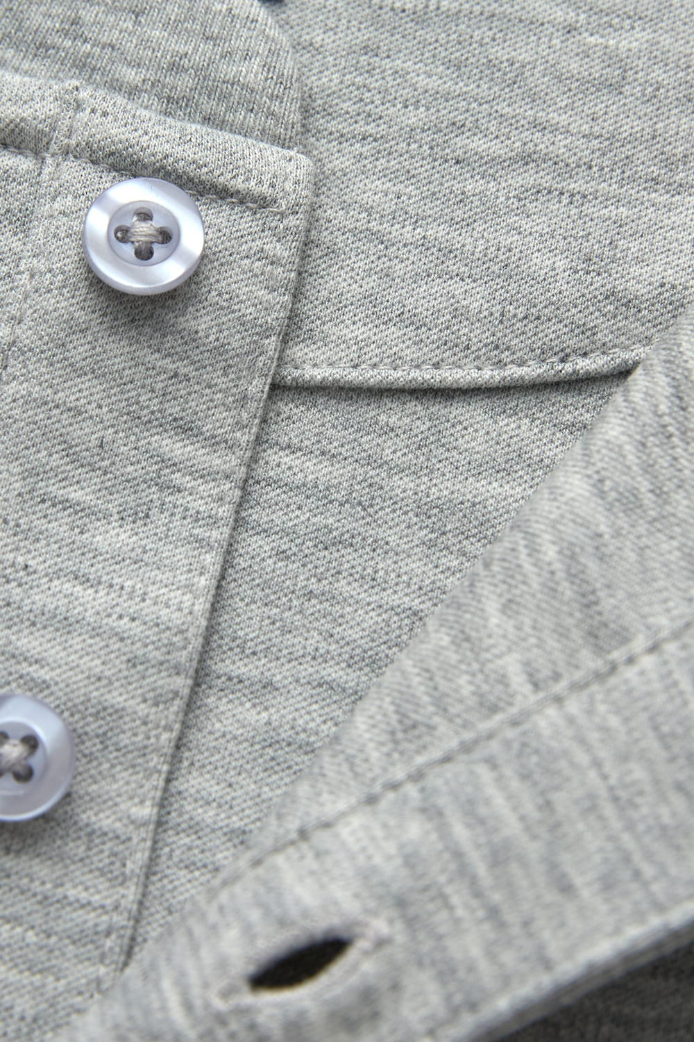 Gray henley top detail showing buttons, placket stitching, and knit texture