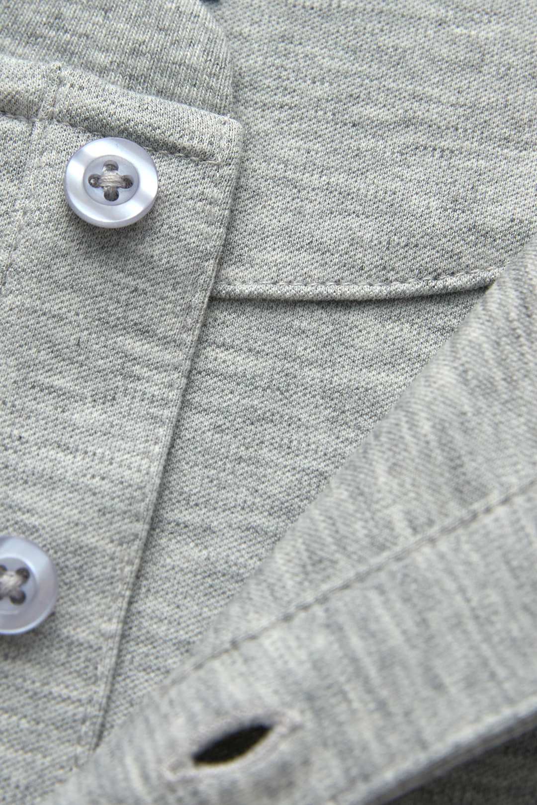 Gray henley top detail showing buttons, placket stitching, and knit texture
