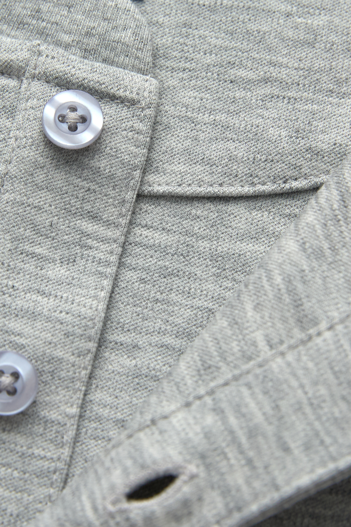 Gray henley top detail showing buttons, placket stitching, and knit texture