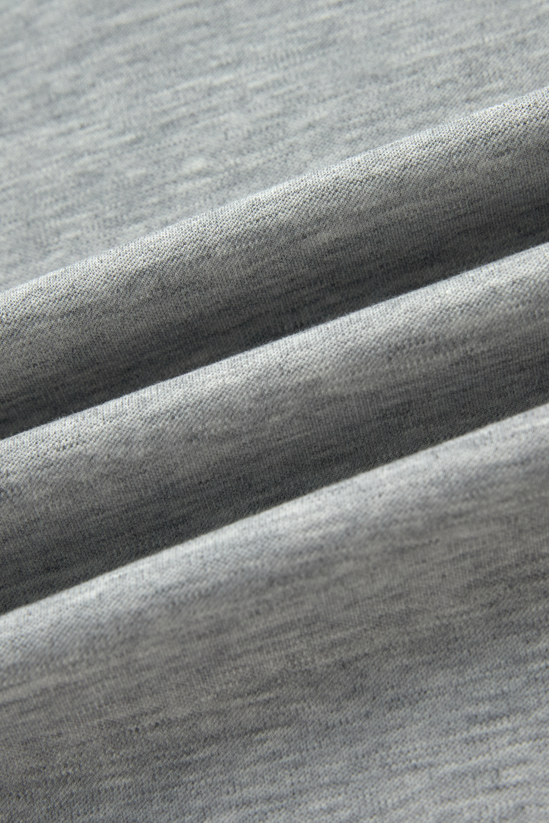 Close-up of the gray top's heathered knit fabric and folded drape