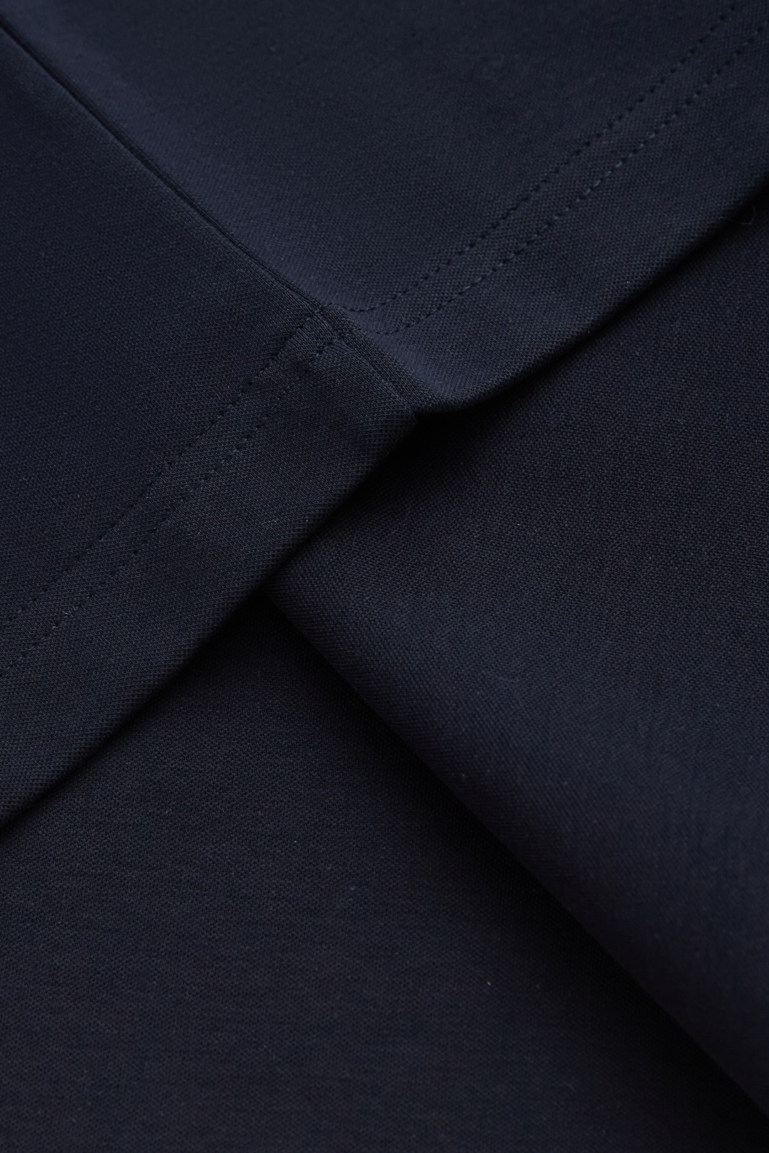 Close-up of the top's dark navy fabric and seam stitching