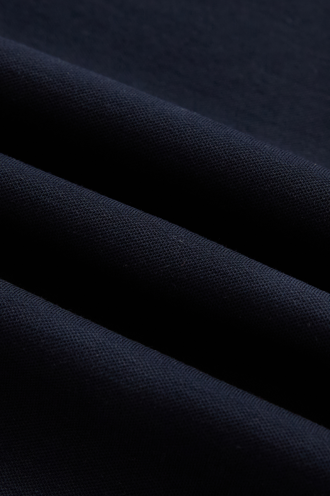 Close-up of the dark navy top's fine textured knit fabric