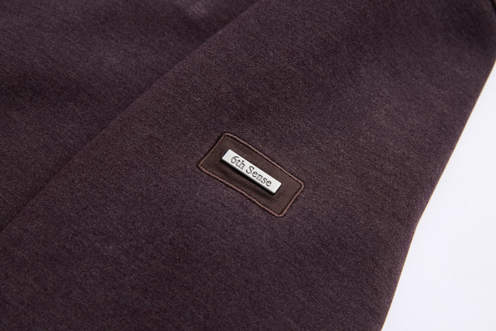 6th Sense 1/4-zip top with small branded label patch on dark plum fabric