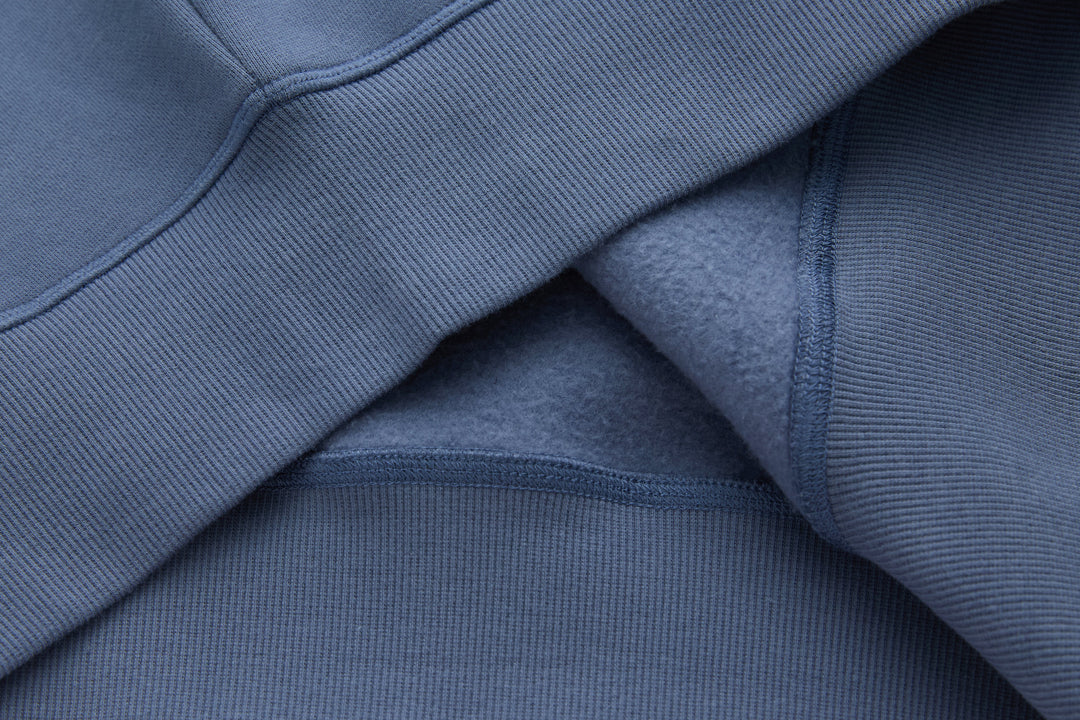 Blue denim hoodie sleeve with ribbed cuff and stitched seam detail