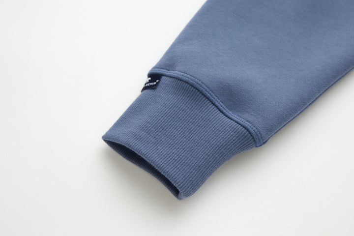 Blue denim hoodie sleeve cuff with ribbed knit hem