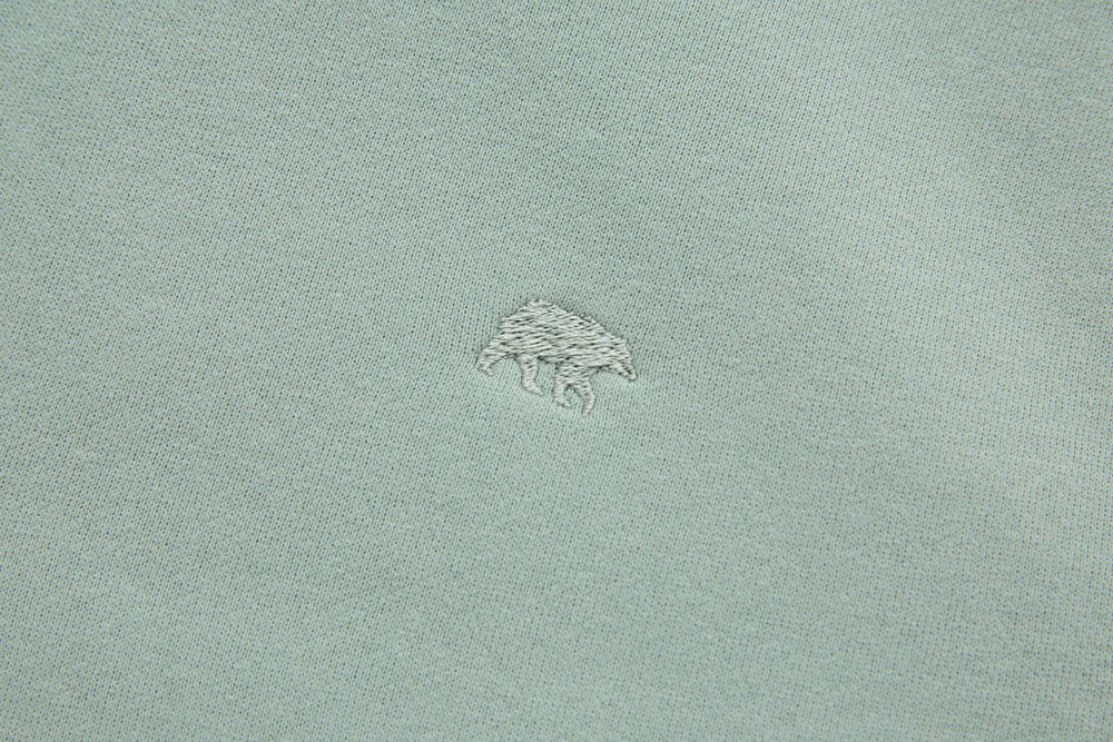 Jade denim hoodie chest logo embroidery, small archer graphic stitched on fabric.