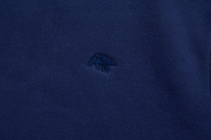 Navy denim hoodie front with small embroidered chest logo