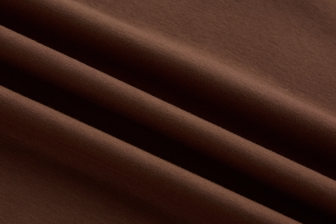 Brown polo shirt fabric close-up with smooth knit texture