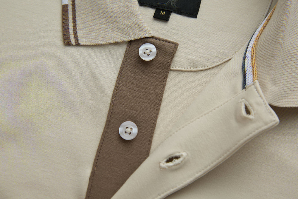 Cream polo shirt with brown inner collar panel and white button placket