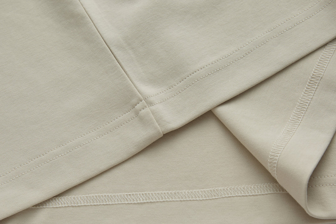 Cream polo shirt with side seam stitching and curved hem