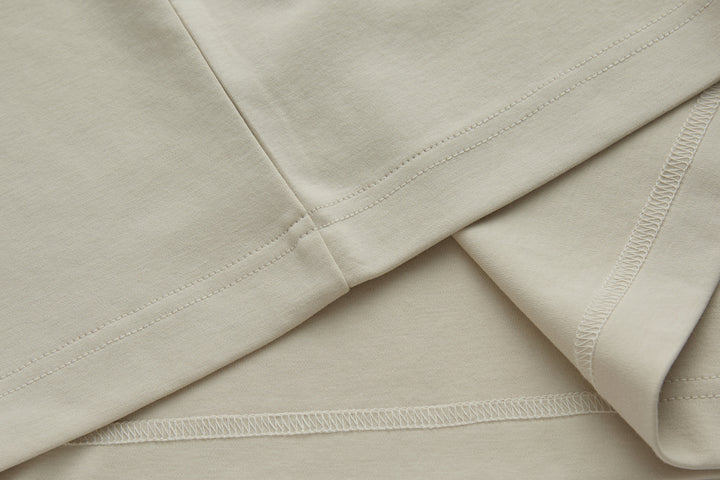 Cream polo shirt with side seam stitching and curved hem