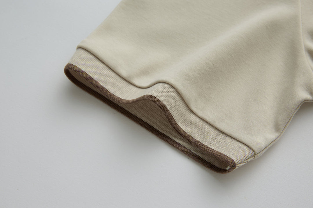 Cream polo shirt sleeve cuff with brown contrast band