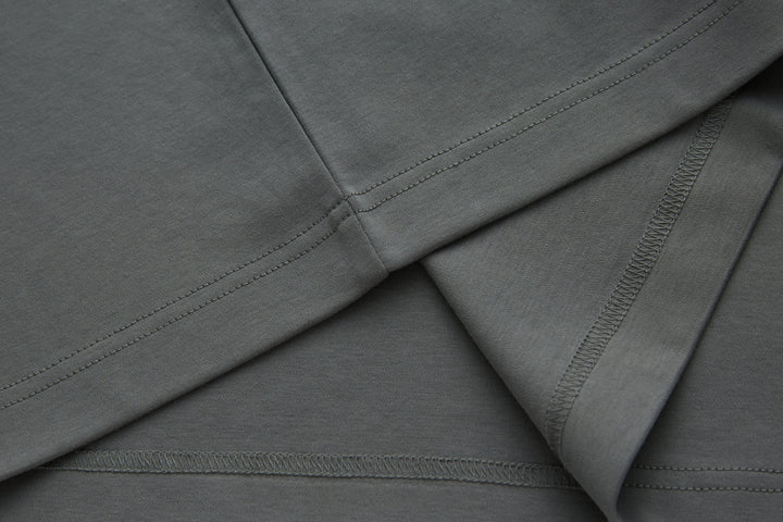 Gray polo shirt sleeve and bottom hem with stitched edging.