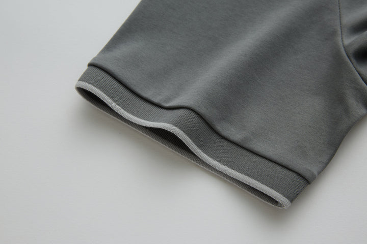 Gray polo shirt sleeve cuff with ribbed trim.