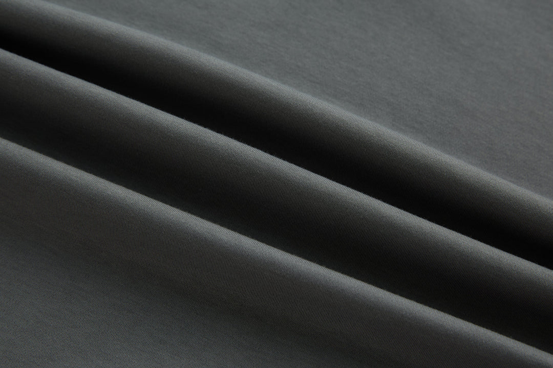 Gray polo shirt fabric close-up, smooth knit texture.