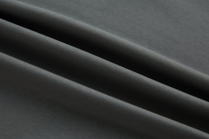 Gray polo shirt fabric close-up, smooth knit texture.