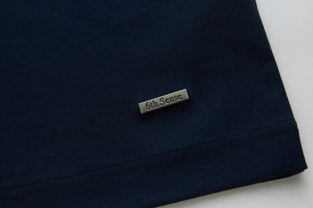 Dark navy polo shirt hem with brand label patch