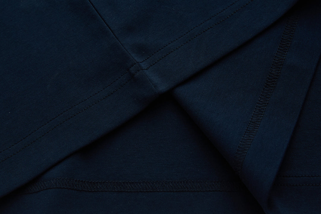 Dark navy polo shirt with stitched seam detail at shoulder