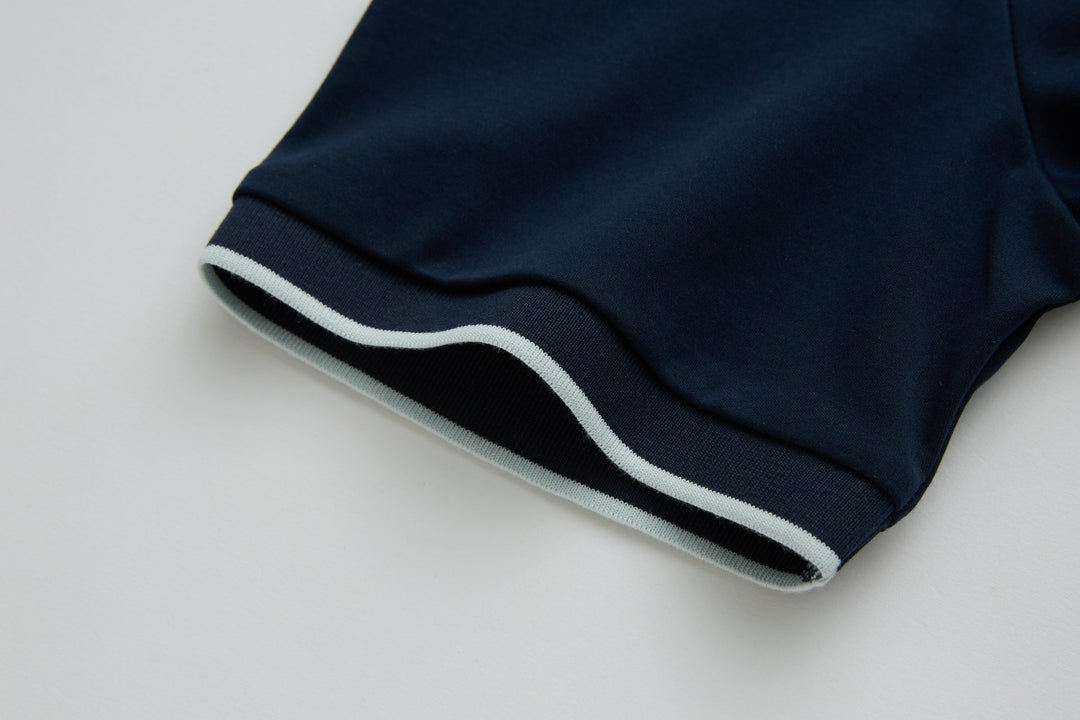 Dark navy polo shirt sleeve hem with white stripe trim
