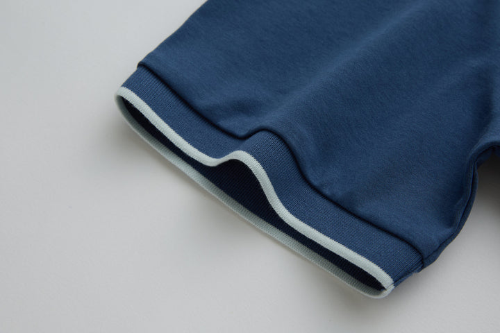 Blue polo shirt sleeve cuff with ribbed hem and white stripe trim