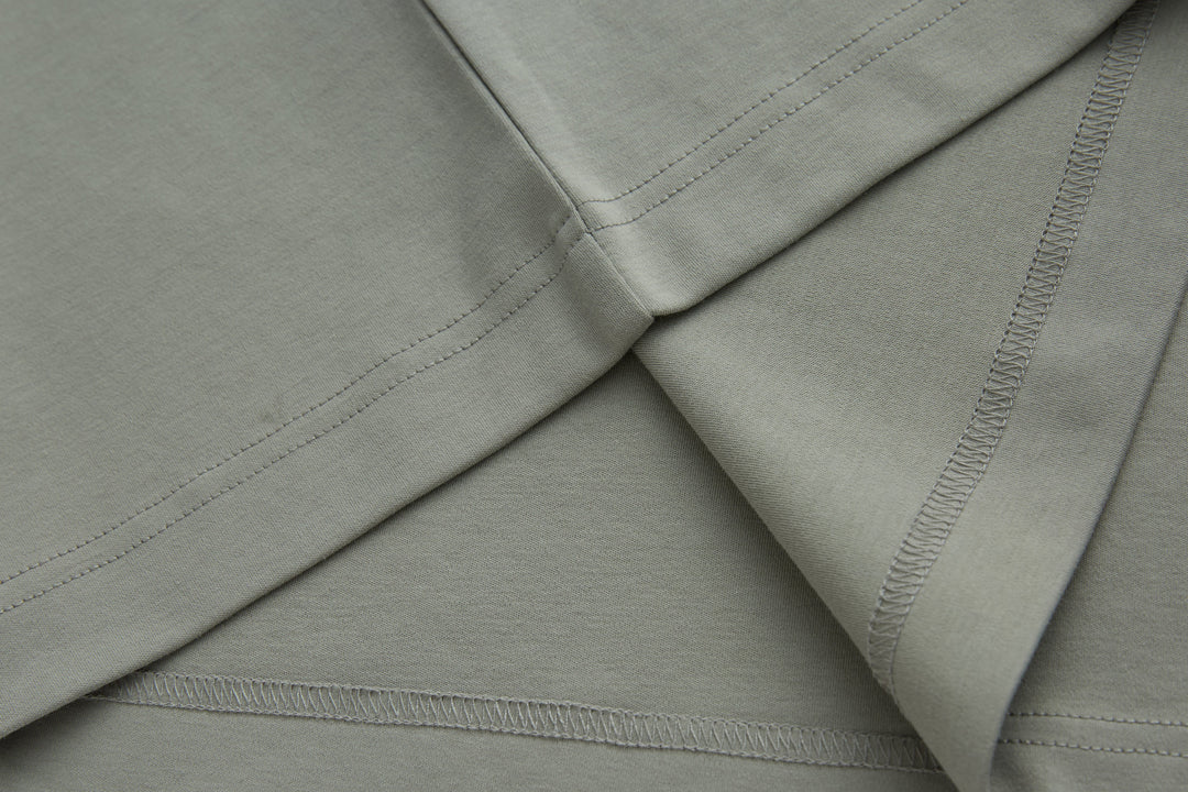 Light gray polo shirt shoulder and side seams with stitched trim