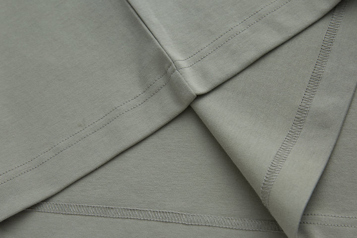 Light gray polo shirt shoulder and side seams with stitched trim