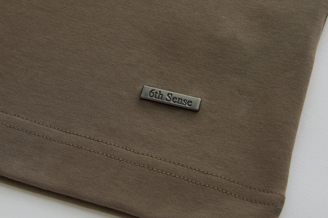 Walnut polo shirt hem with stitched edge and small 6th Sense chest logo