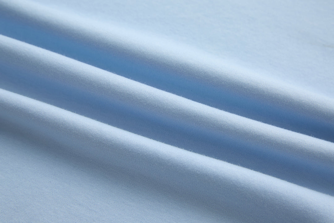 Light blue cotton t-shirt fabric close-up with smooth knit texture