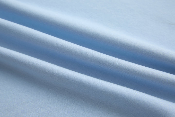 Light blue cotton t-shirt fabric close-up with smooth knit texture