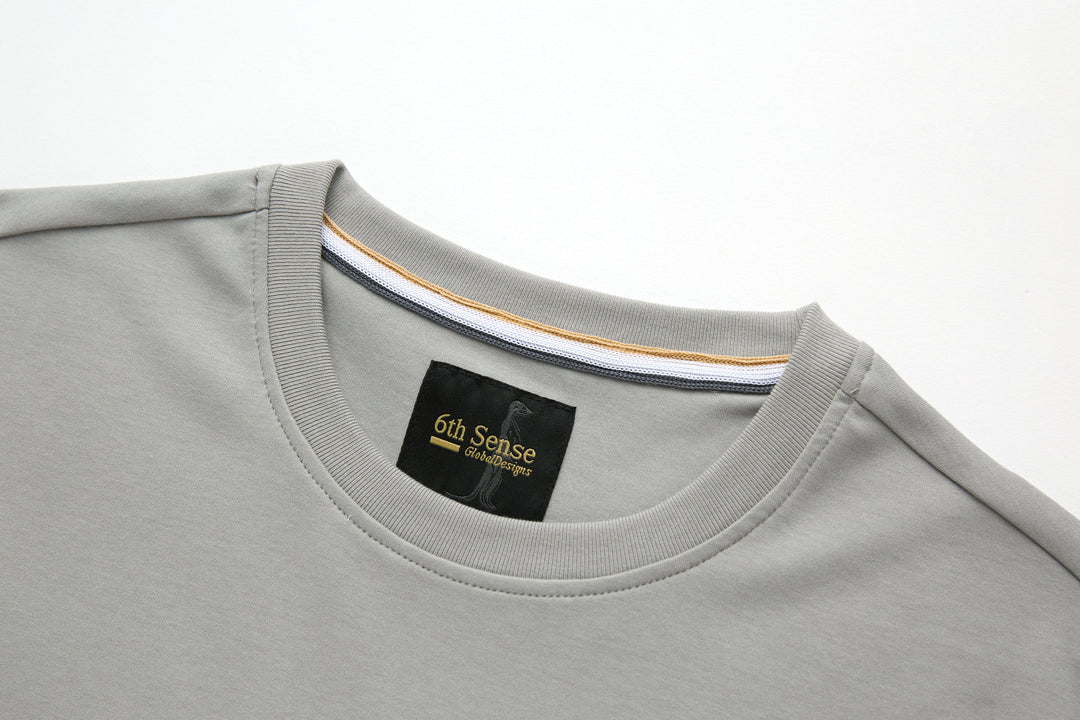 Light gray crewneck T-shirt with ribbed collar and 6th Sense neck label