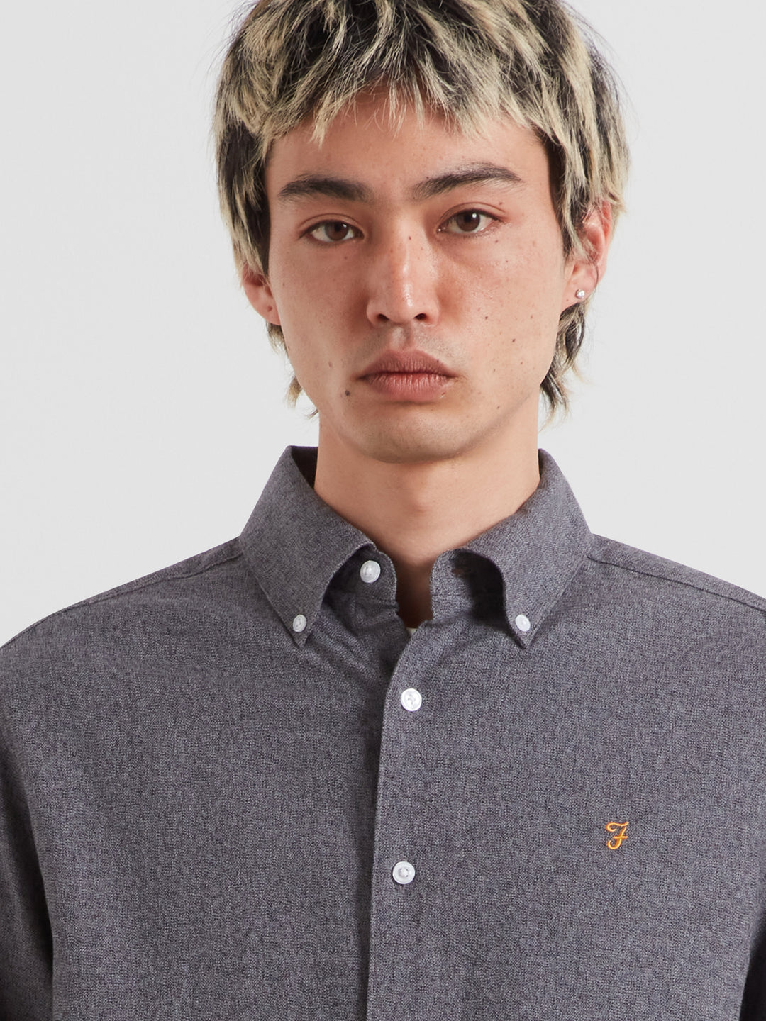 Dark blue-gray long-sleeve button-up shirt with small chest logo and button cuffs