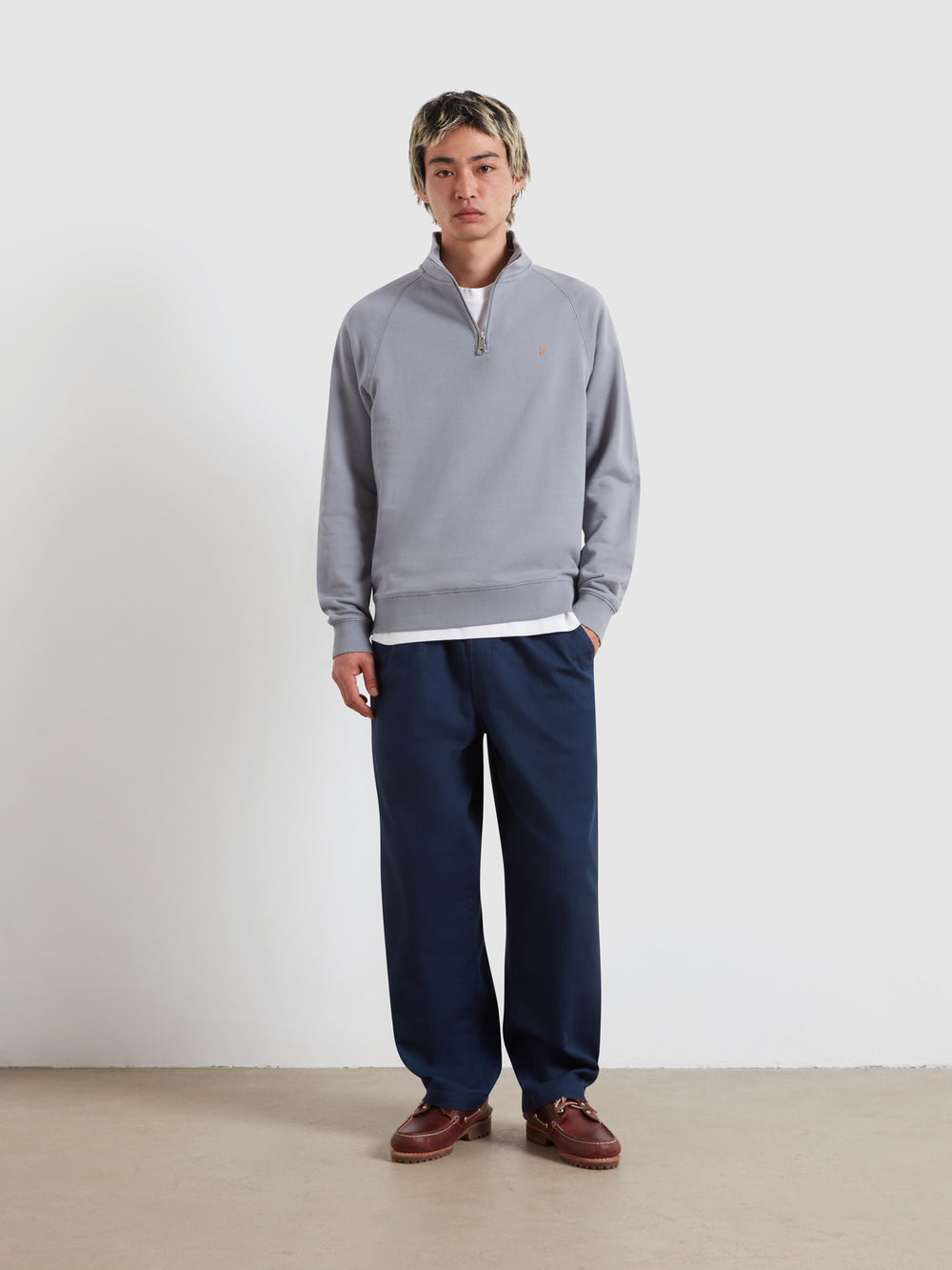 Farah Arnold quarter-zip top with stand collar, light blue; worn with navy trousers
