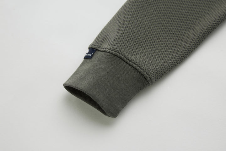 Grey 1/4-zip top with ribbed sleeve cuff and small logo patch