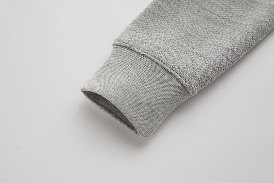 Heather gray sleeve cuff on a 1/4-zip top with stitched hem