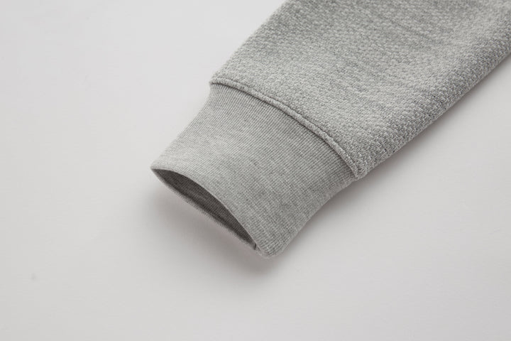 Heather gray sleeve cuff on a 1/4-zip top with stitched hem