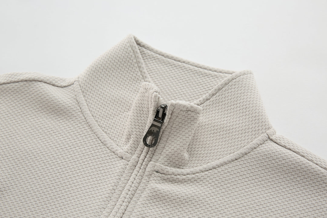 Light beige waffle-knit quarter-zip top with metal zipper at neckline